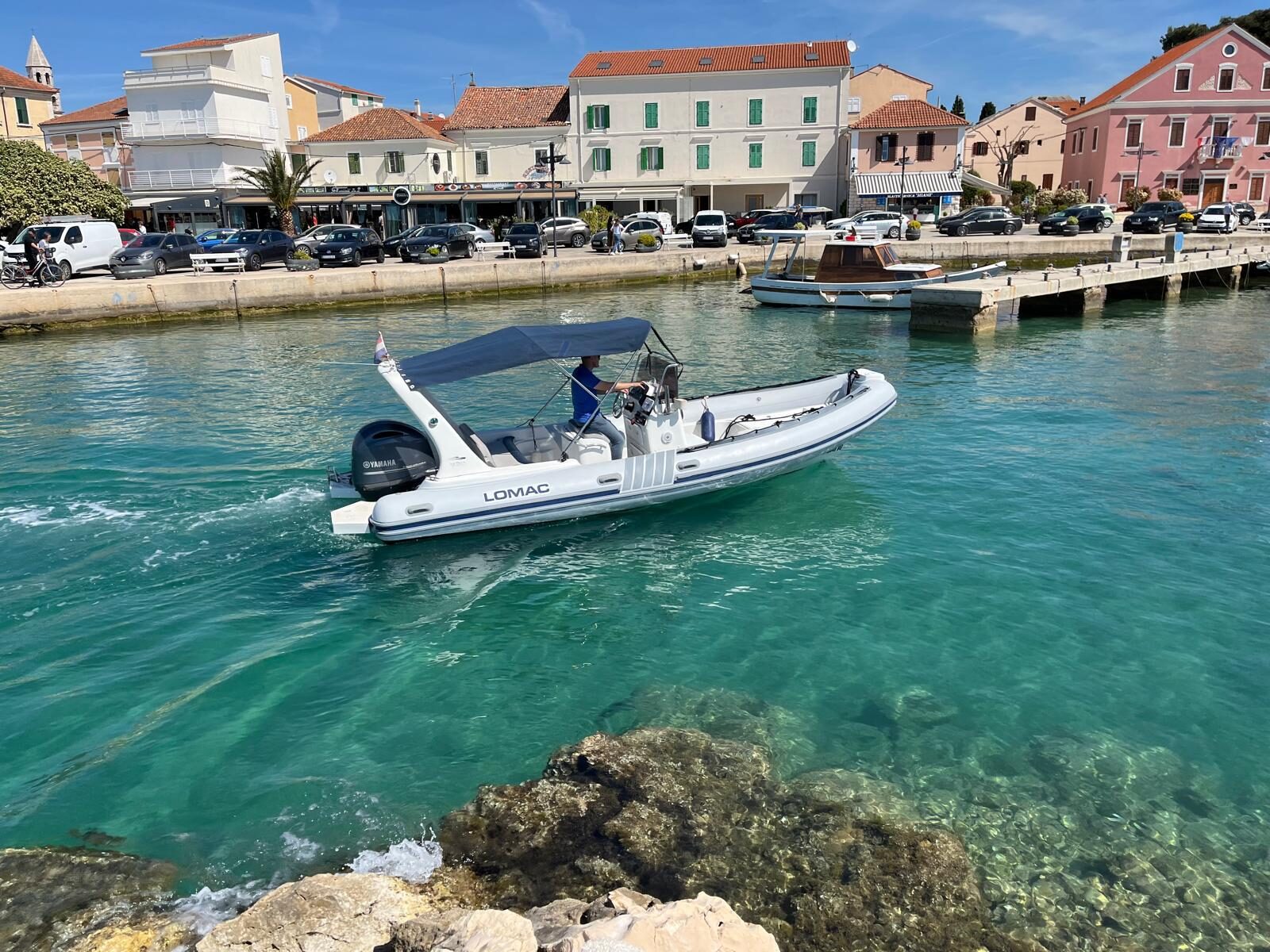 Lomac 660 RIB with navy bimini cruising on turquoise water near Biograd marina